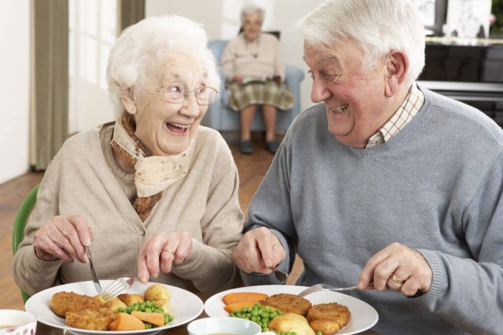 Couple senior discutant joyeusement au dîner.