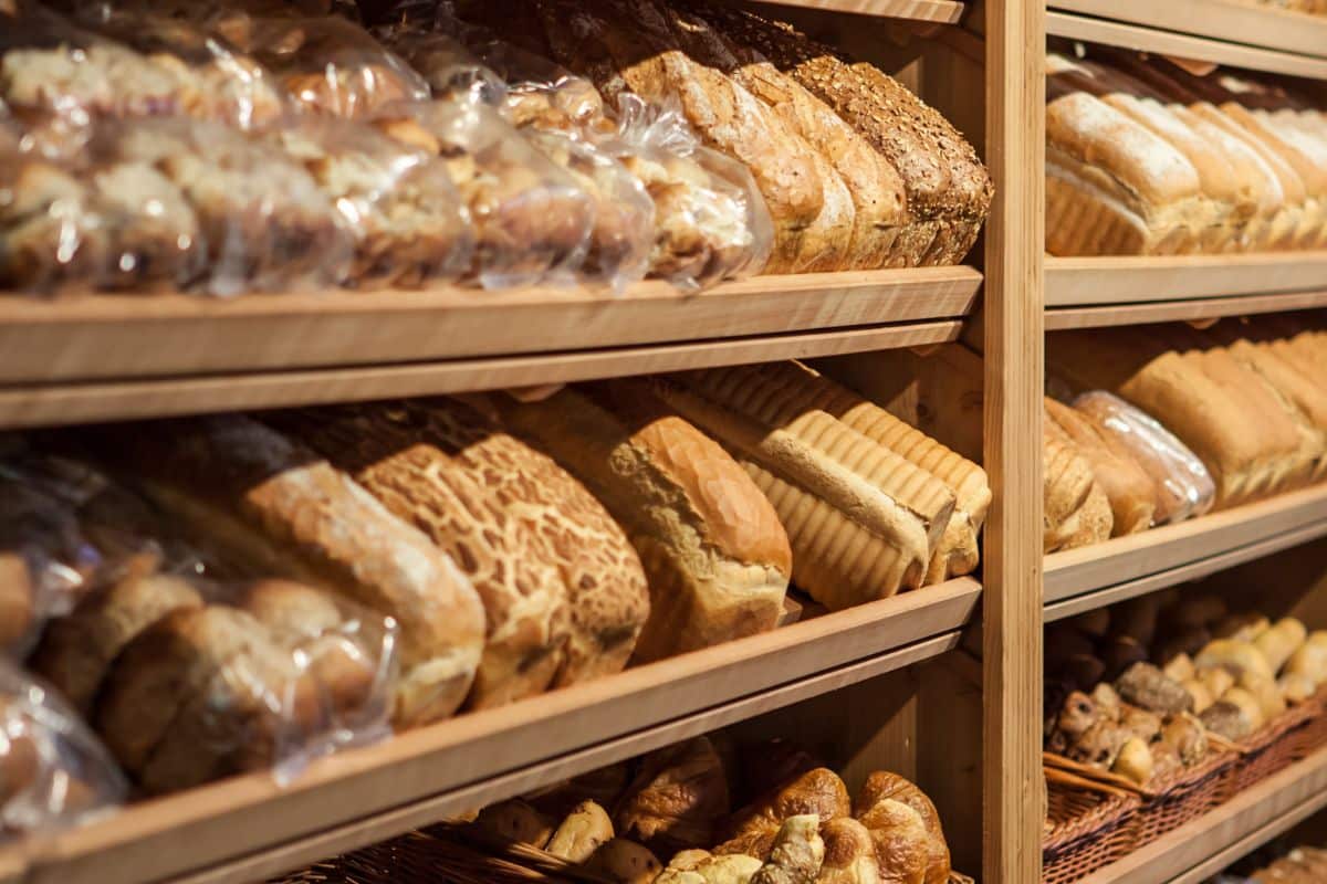 Étagères remplies de pains variés en boulangerie.