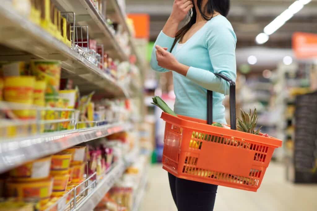Femme choisissant produits dans un supermarché.