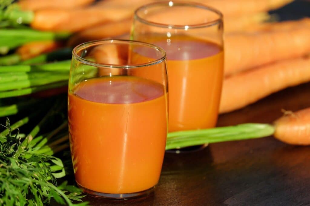 Verres de jus de carotte frais sur table.