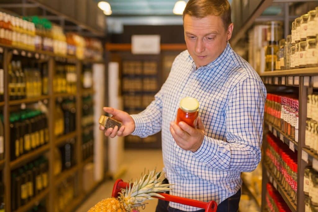 Homme choisissant des produits dans un supermarché.