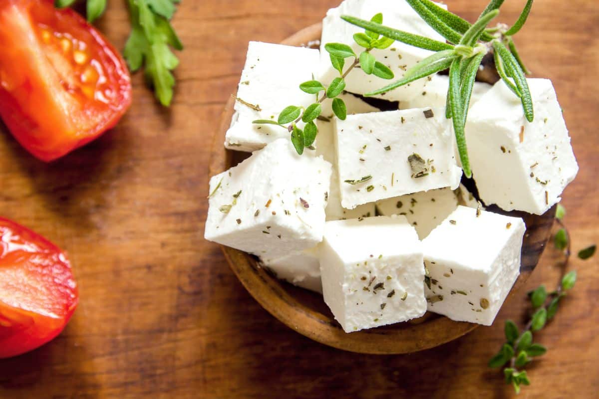 Cubes de fromage assaisonné avec herbes et tomates.