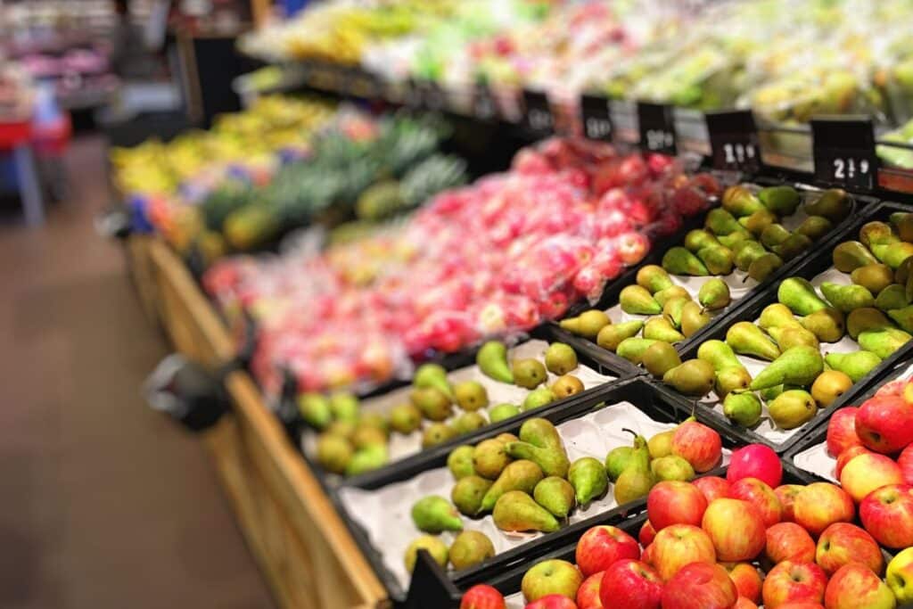 Étal de fruits au supermarché avec pommes et poires.