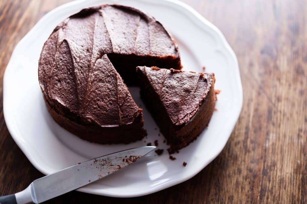 Gâteau au chocolat sur assiette blanche, part coupée.
