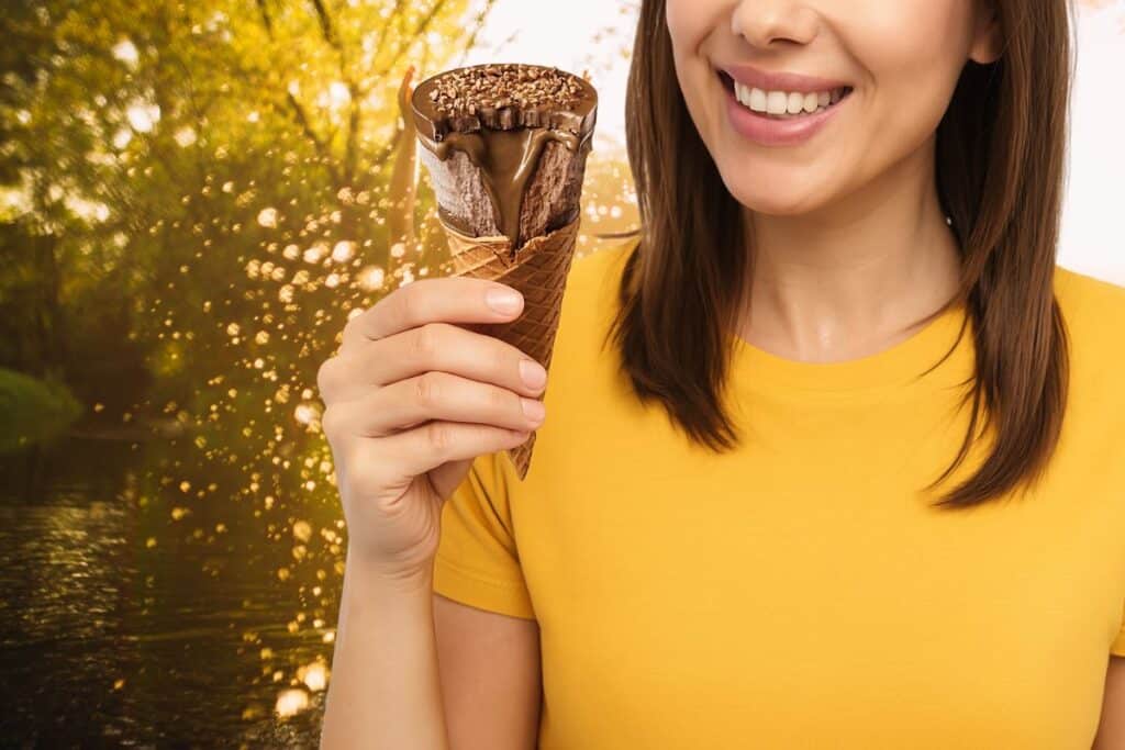 Femme tenant une glace chocolat au soleil.
