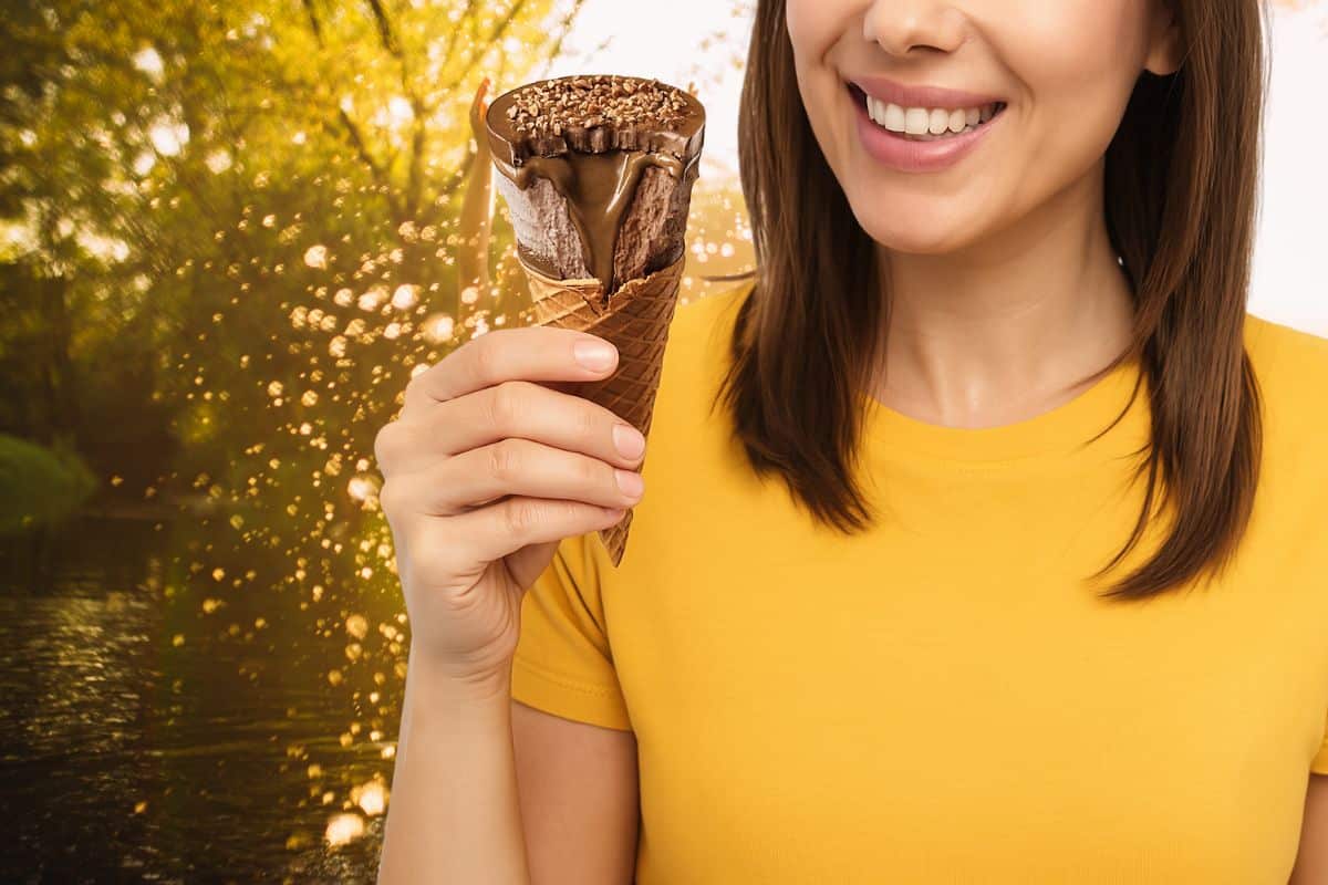 Femme tenant une glace chocolat au soleil.