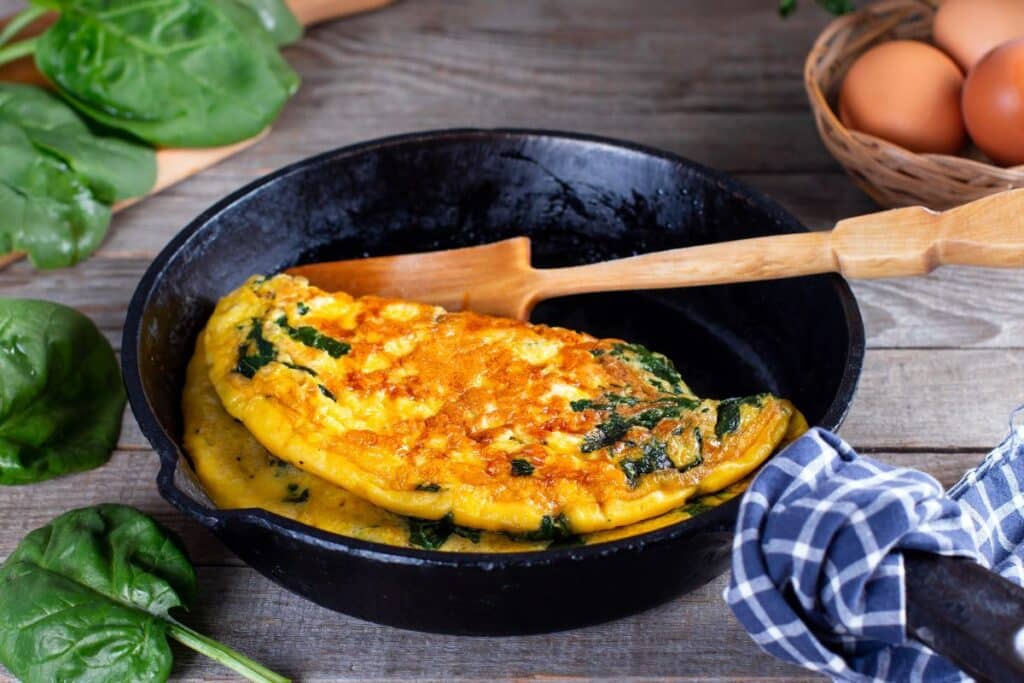 Omelette aux épinards dans une poêle en fonte.