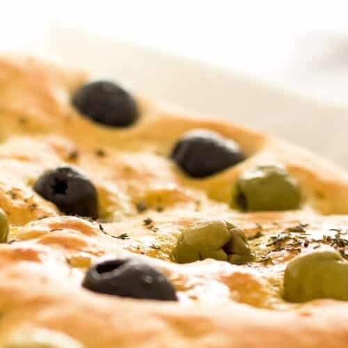 Focaccia aux olives vertes et noires sur table.