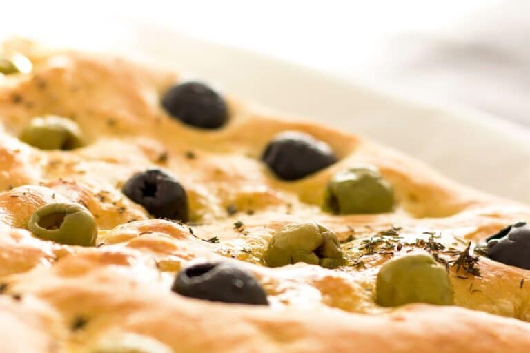 Focaccia aux olives vertes et noires sur table.