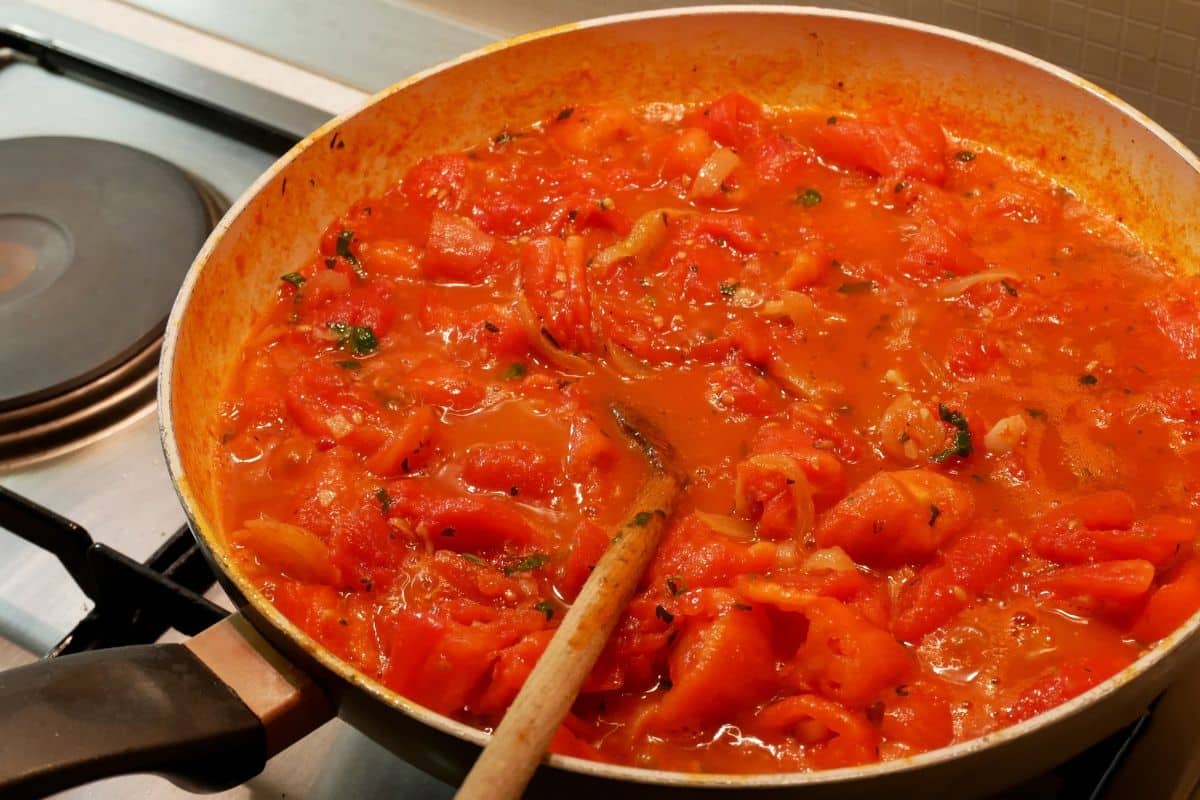 Poêle de sauce tomate en cuisson sur la cuisinière.