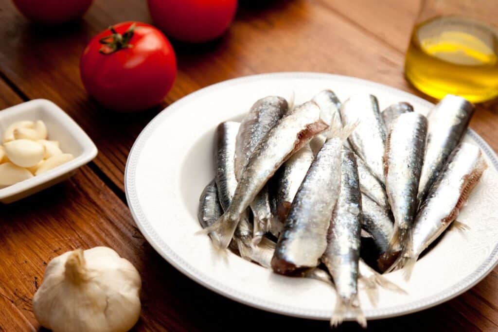 Assiette de sardines avec ail et tomates.