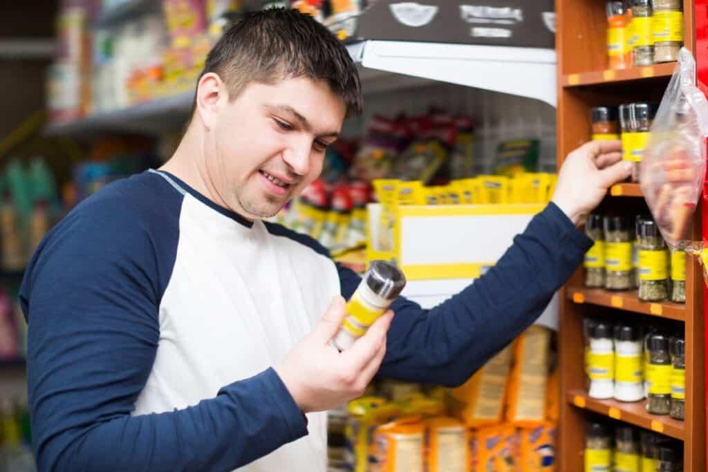 Homme choisissant un produit dans un magasin.