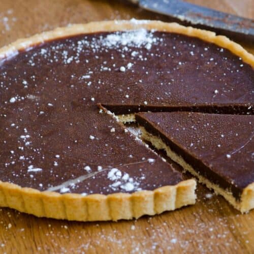 Tarte au chocolat avec une part coupée.