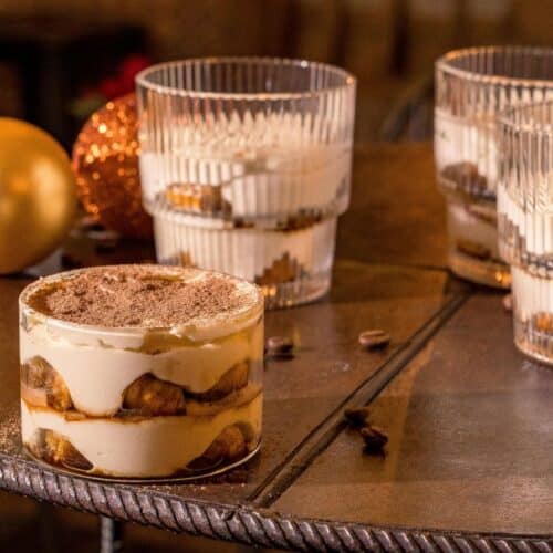 Desserts en verrines sur table avec boules dorées.