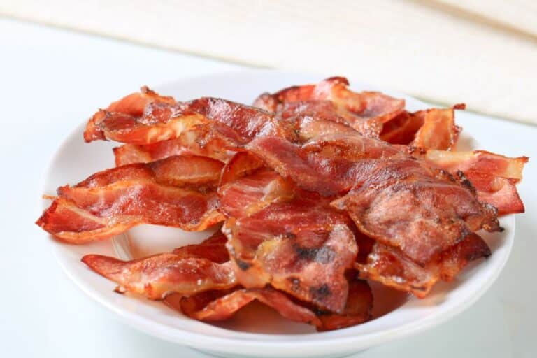 Assiette de tranches de bacon cuites.