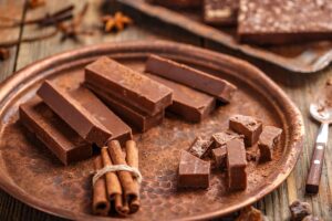 Tablette de chocolat et cannelle sur plateau cuivre.