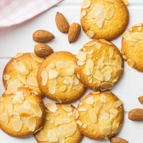 Biscuits aux amandes tranchées sur nappe rose.