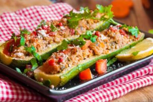 Courgettes farcies au four, herbes et légumes.