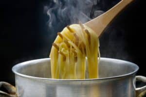 Spaghetti cuit sortant d'une casserole fumante.