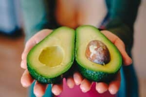 Avocat mûr coupé en deux dans des mains