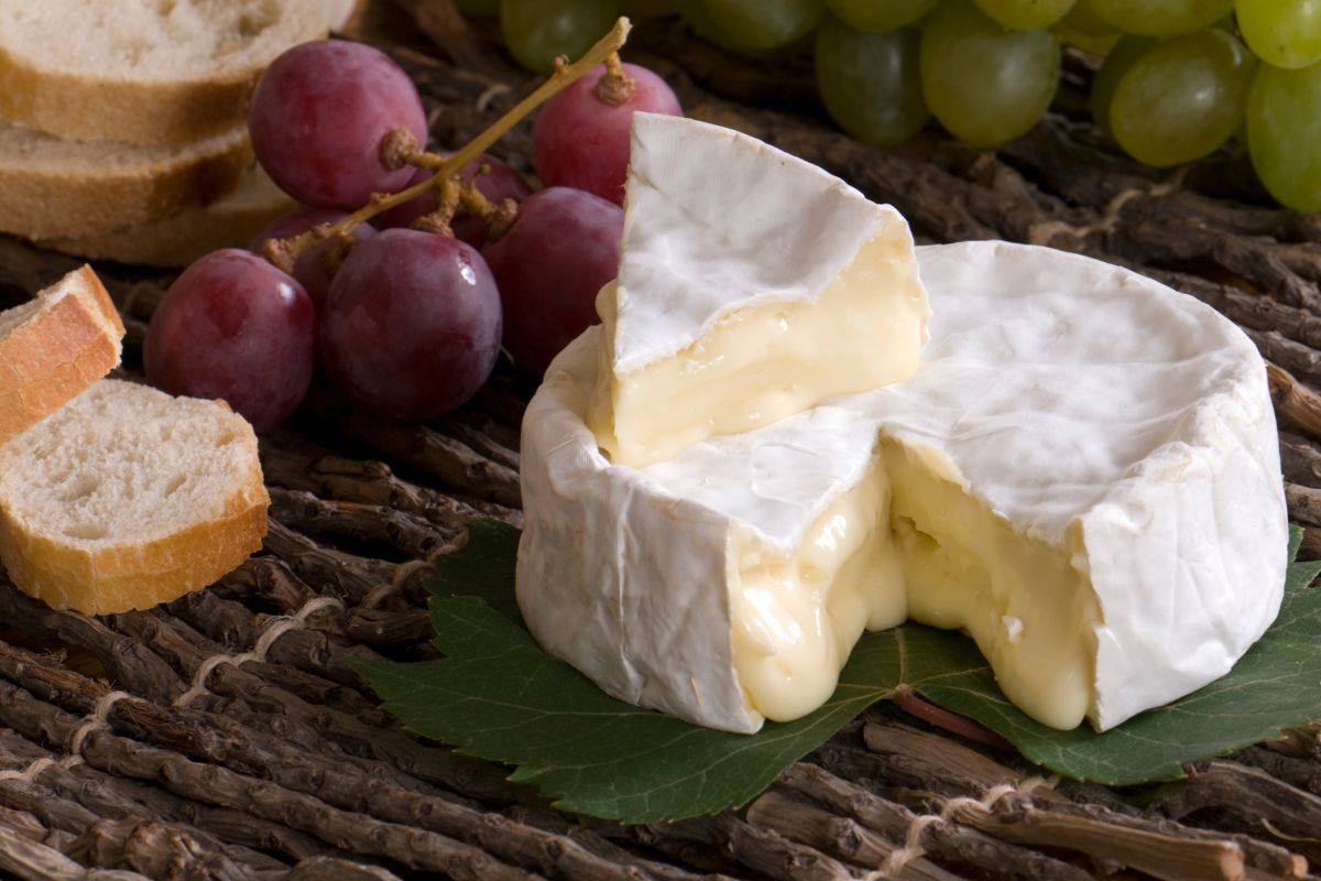 Camembert, raisins et pain sur nappe en lin.