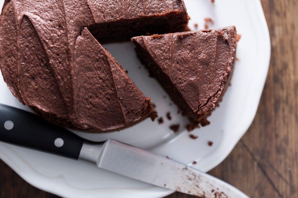 Gâteau chocolaté avec part coupée sur assiette.