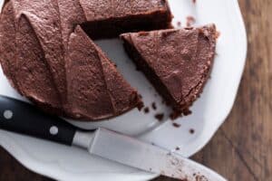 Gâteau chocolaté avec part coupée sur assiette.
