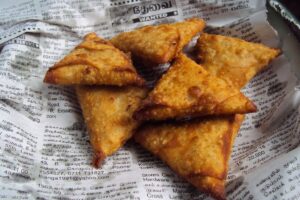 Samosas frits sur du journal imprimé.