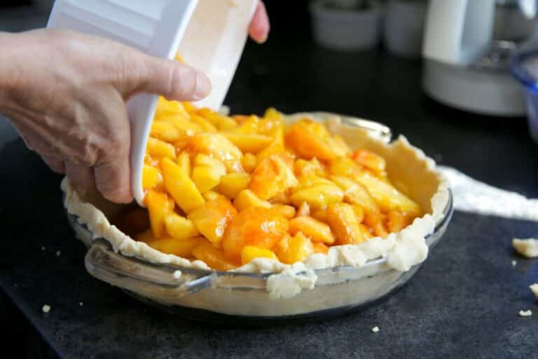 Préparation d'une tarte aux pêches maison.