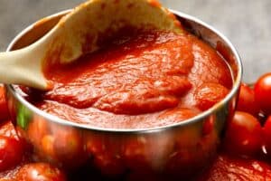 Sauce tomate dans une casserole avec louche.