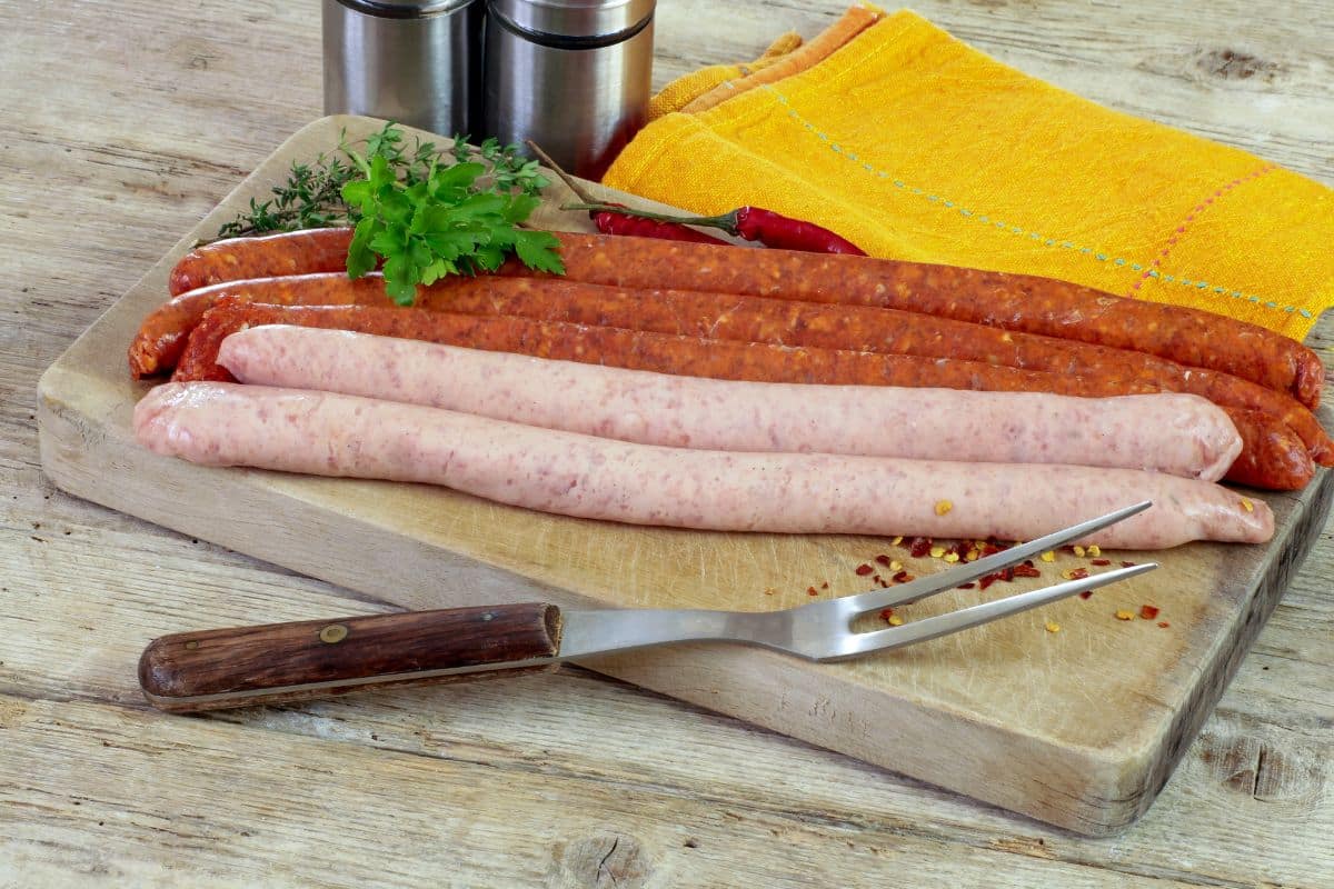 Planche de saucisses variées avec herbes.