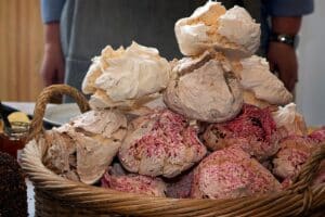 Panier de grosses meringues colorées empilées.