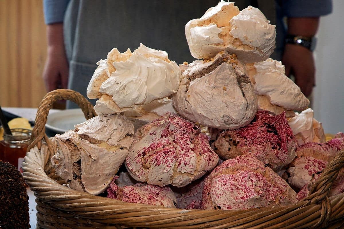 Panier de grosses meringues colorées empilées.