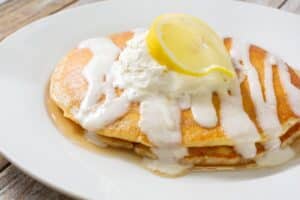 Crêpes au citron avec crème sur assiette blanche.