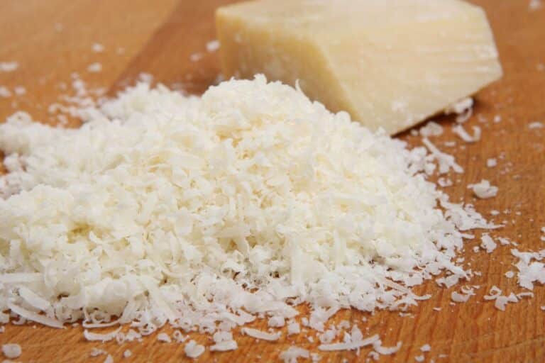 Fromage râpé sur planche en bois.