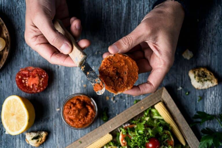 Personne prépare une tartine avec de la sauce tomate.