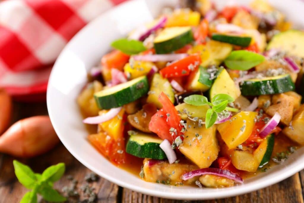 Salade de légumes méditerranéens colorée dans un bol blanc.