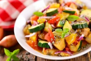 Salade de légumes méditerranéens colorée dans un bol blanc.