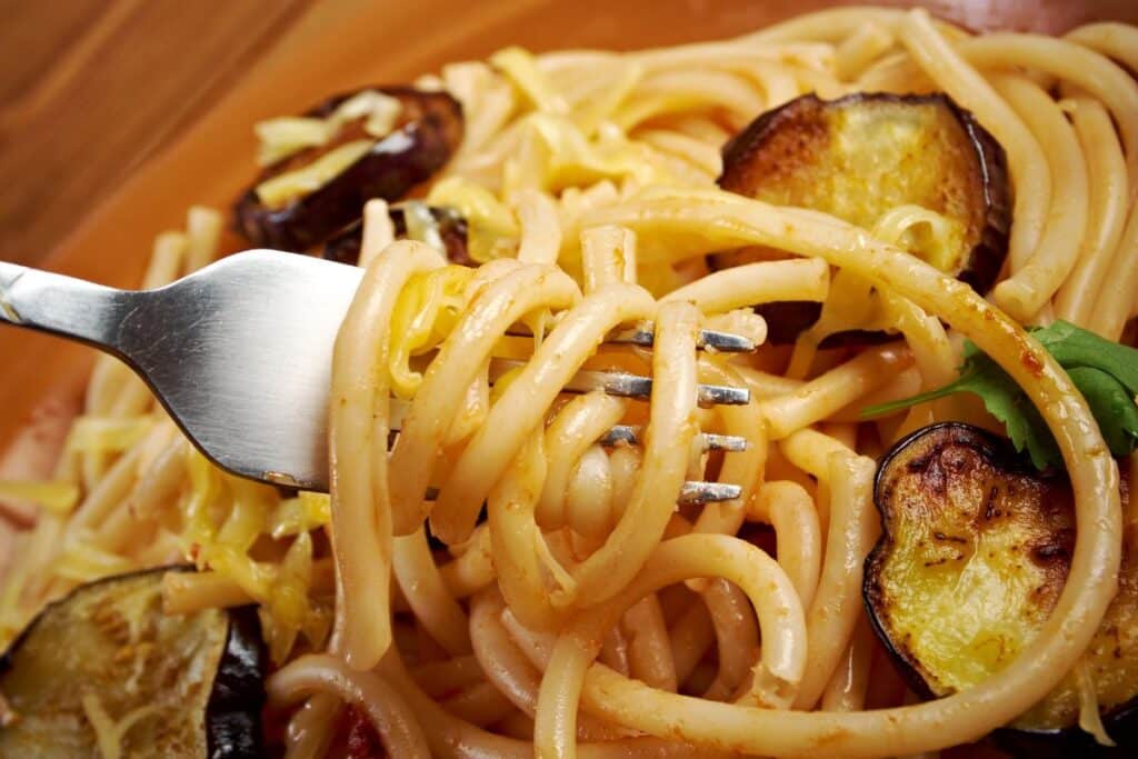 Fourchette enroulée de pâtes avec aubergines.