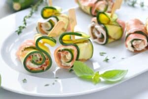 Roulés de courgettes et saumon sur assiette blanche.