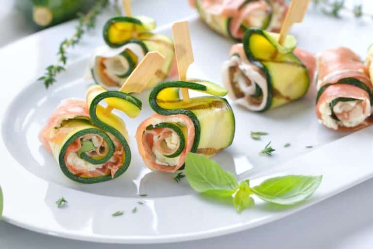 Roulés de courgettes et saumon sur assiette blanche.