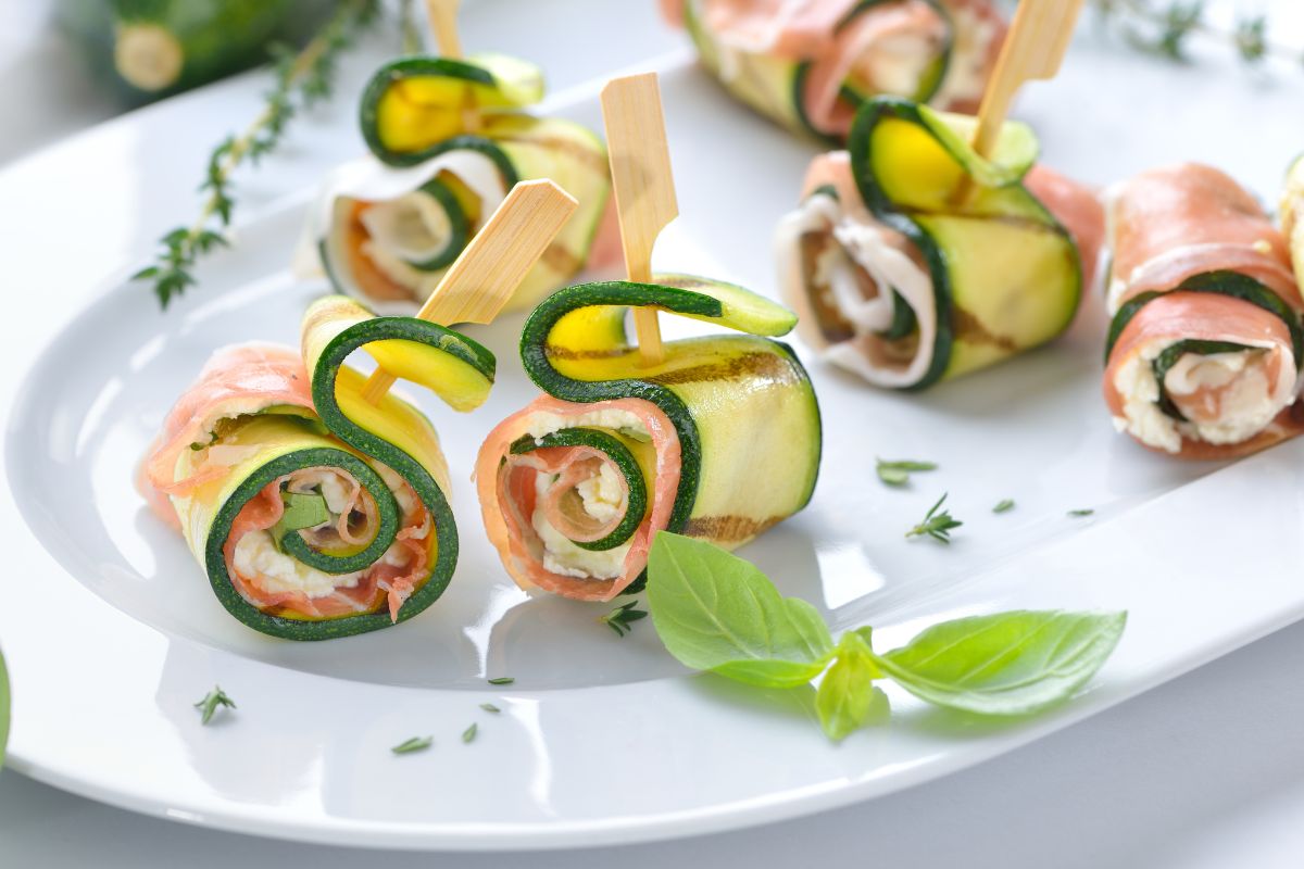 Roulés de courgettes et saumon sur assiette blanche.
