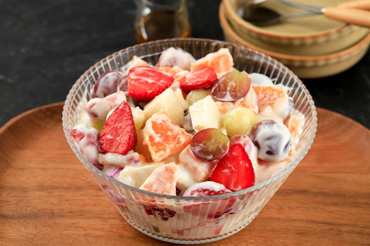 Salade de fruits colorée et crémeuse dans un bol.