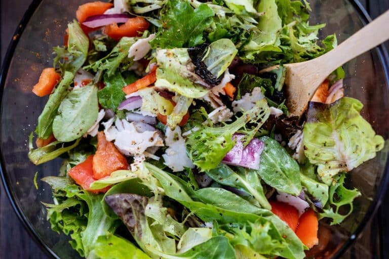 Salade mixte avec légumes et morceaux de poulet.