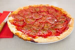 Tarte tomate sur nappe rouge avec couteau