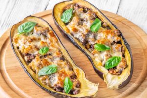 Aubergines farcies au four garnies de fromage.
