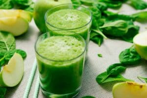 Deux verres de smoothie vert pomme-épinard.