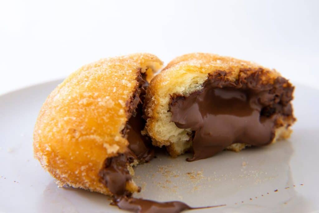 Beignet fourré au chocolat sur assiette.