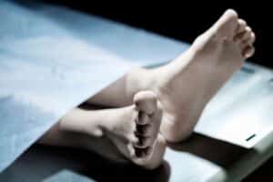 Pieds sous un drap sur une table.