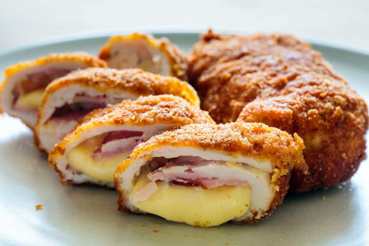 Tranches de cordon bleu croustillant, fromage fondant visible.